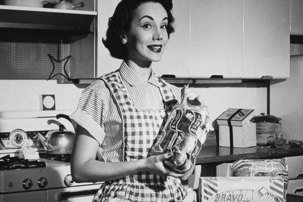 A housewife showing off a loaf of all-important sliced bread.