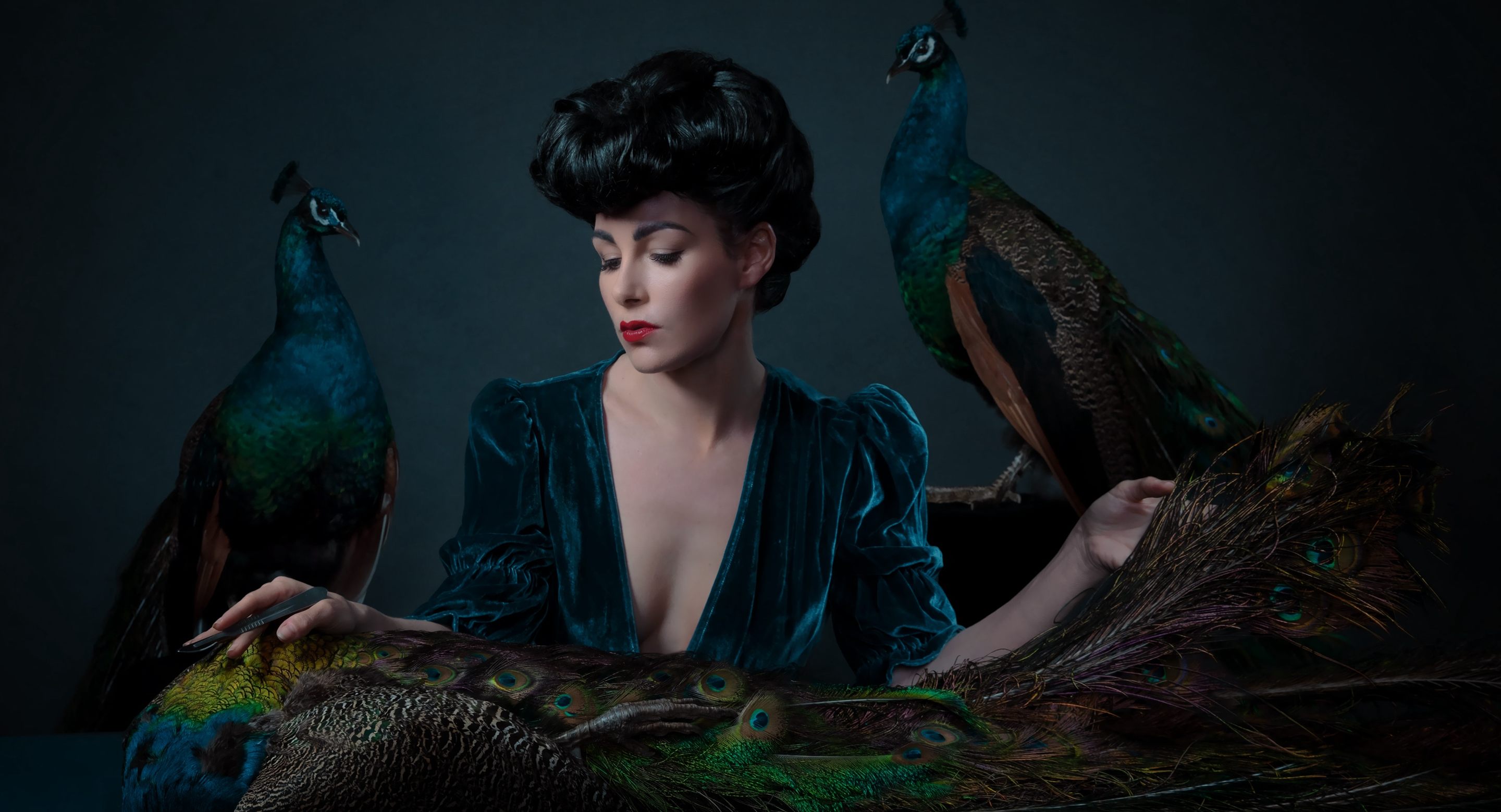 Allis Markham, an Atlas Obscura Courses instructor, poses with two taxidermied peacocks.
